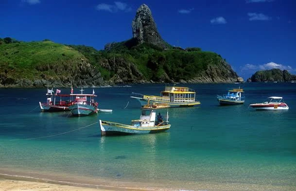 Barcos coloridos sobre o mar cristalino de Noronha